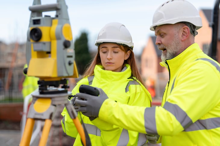 Apprentice surveying a building site