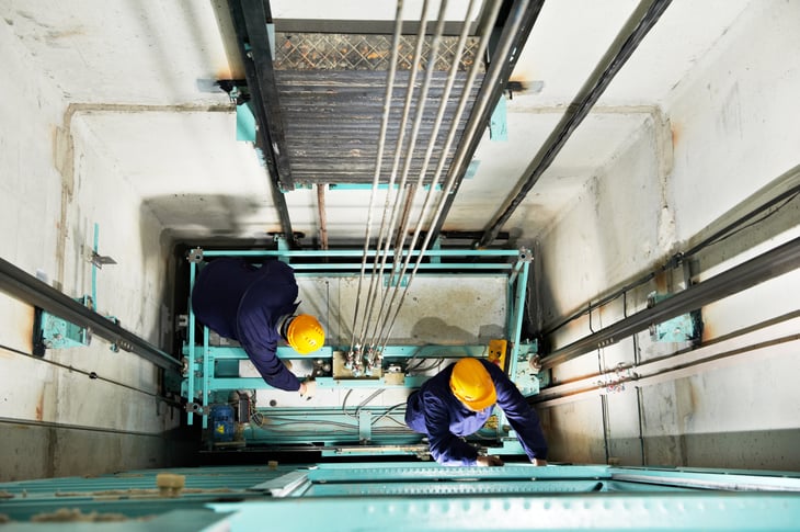 two men repairing lift