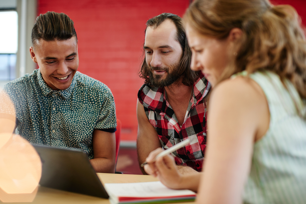 Unposed group of creative business people in an open concept office brainstorming their next project.
