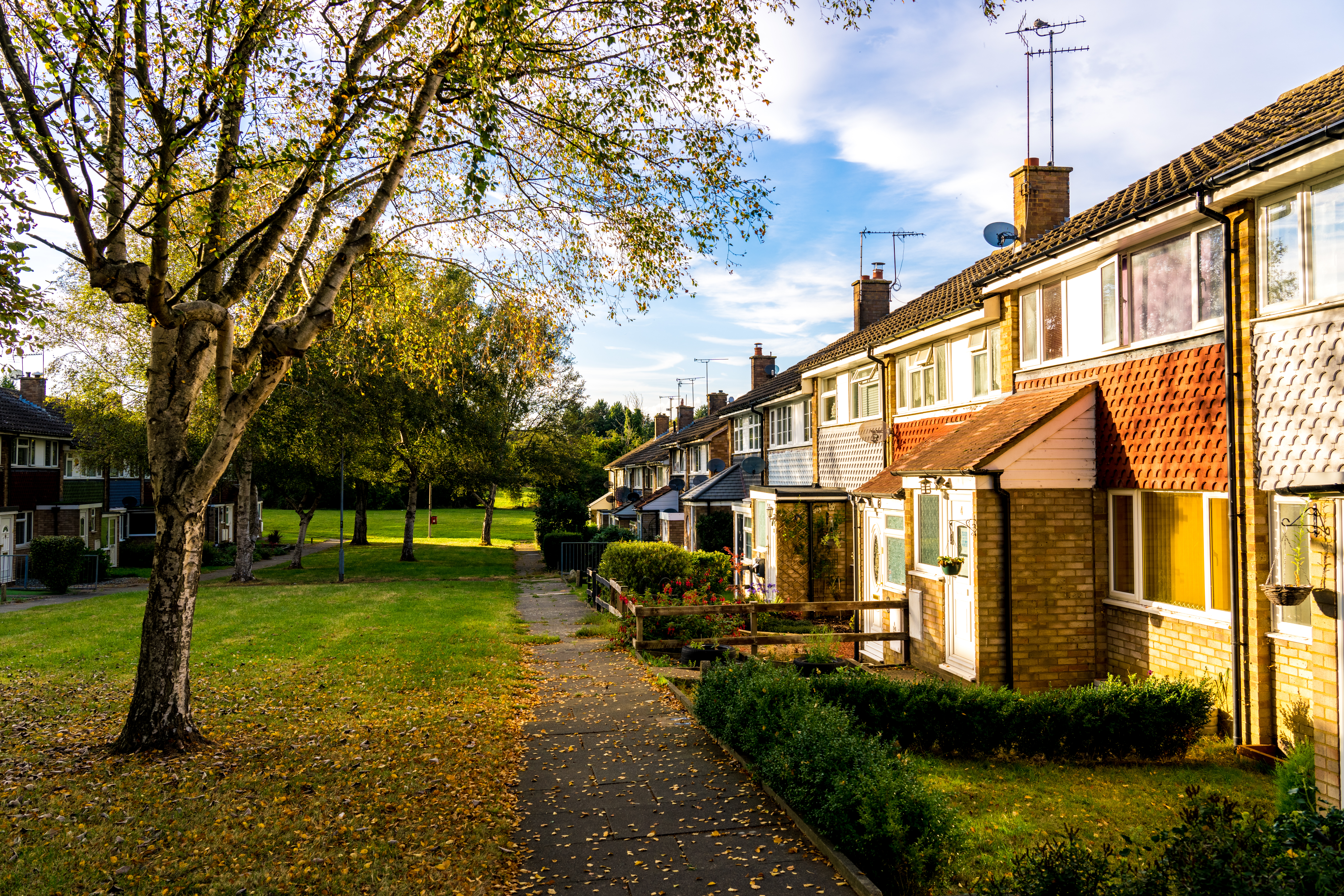 Houses oppsite a grass field