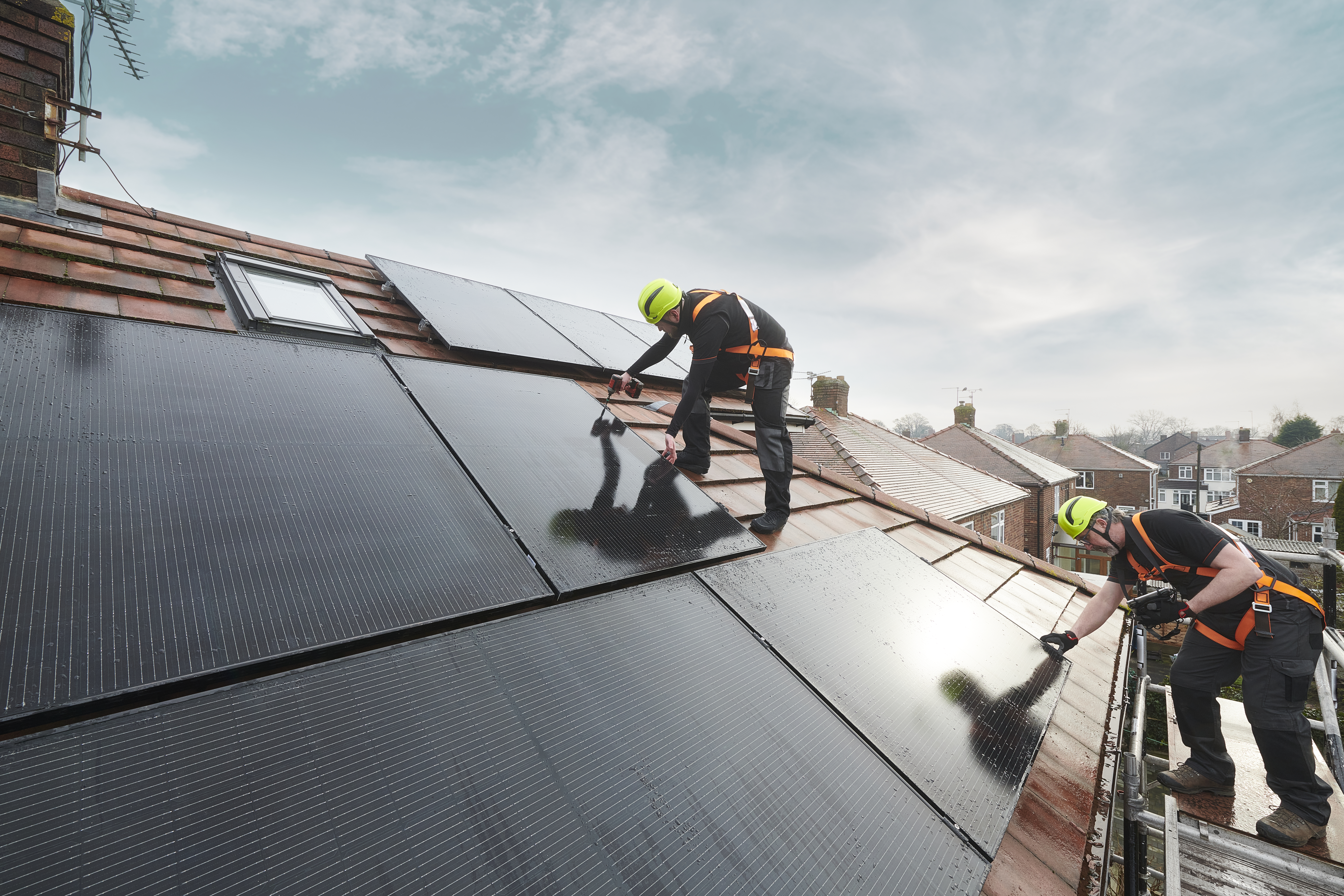 Istock image of guys laying solar panels on a house roof